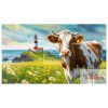 A cow on a medow with lots of flowers and a lighthouse in Germany