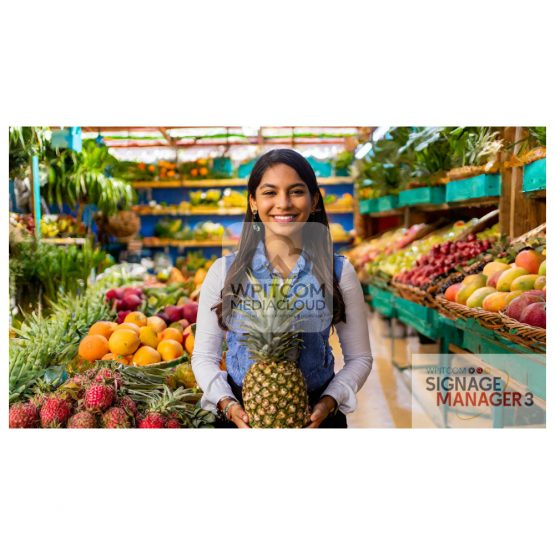A young lady presenting a pineapple in a fruit and vegetable store