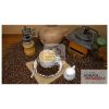 A cup of black coffee with cream on a table with beans